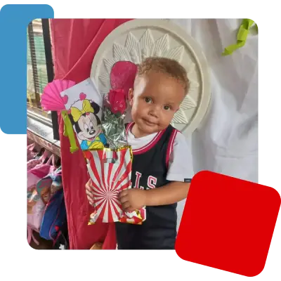 A preschool child holding a Valentine's Day gift.